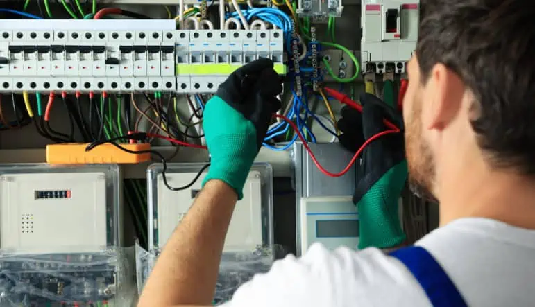 electrician checking electric current with multimeter indoors, c