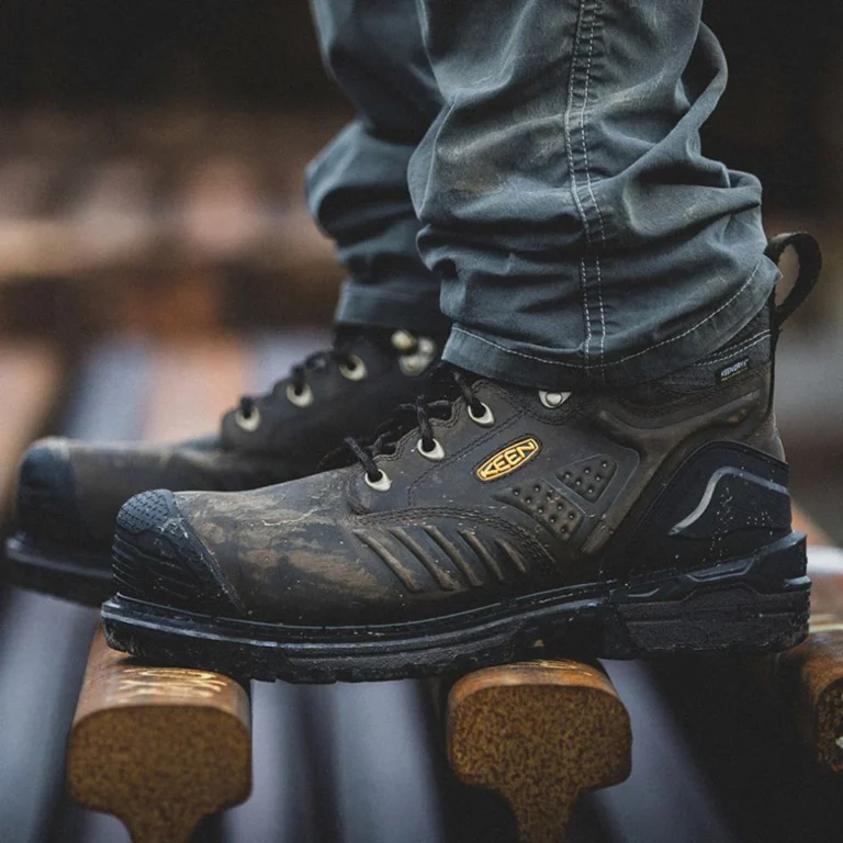 Close-up of rugged black work boots on wood.
