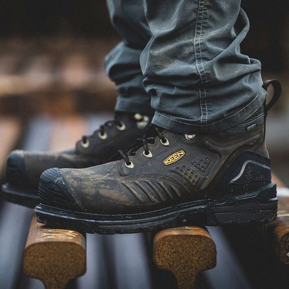Close-up of rugged black work boots on wood.