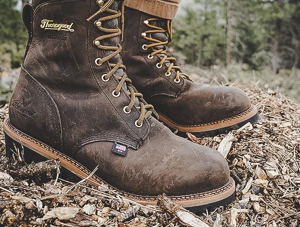 Brown work boots on a rustic ground.