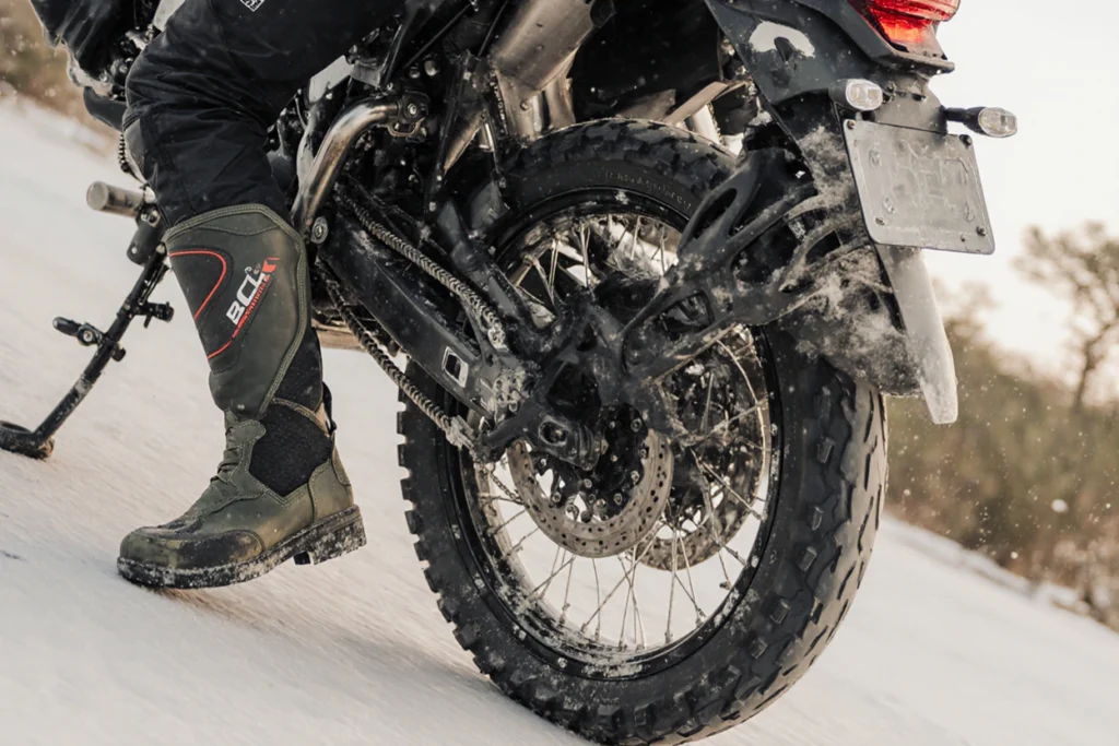 Close-up of motorcycle tire and riding boots
