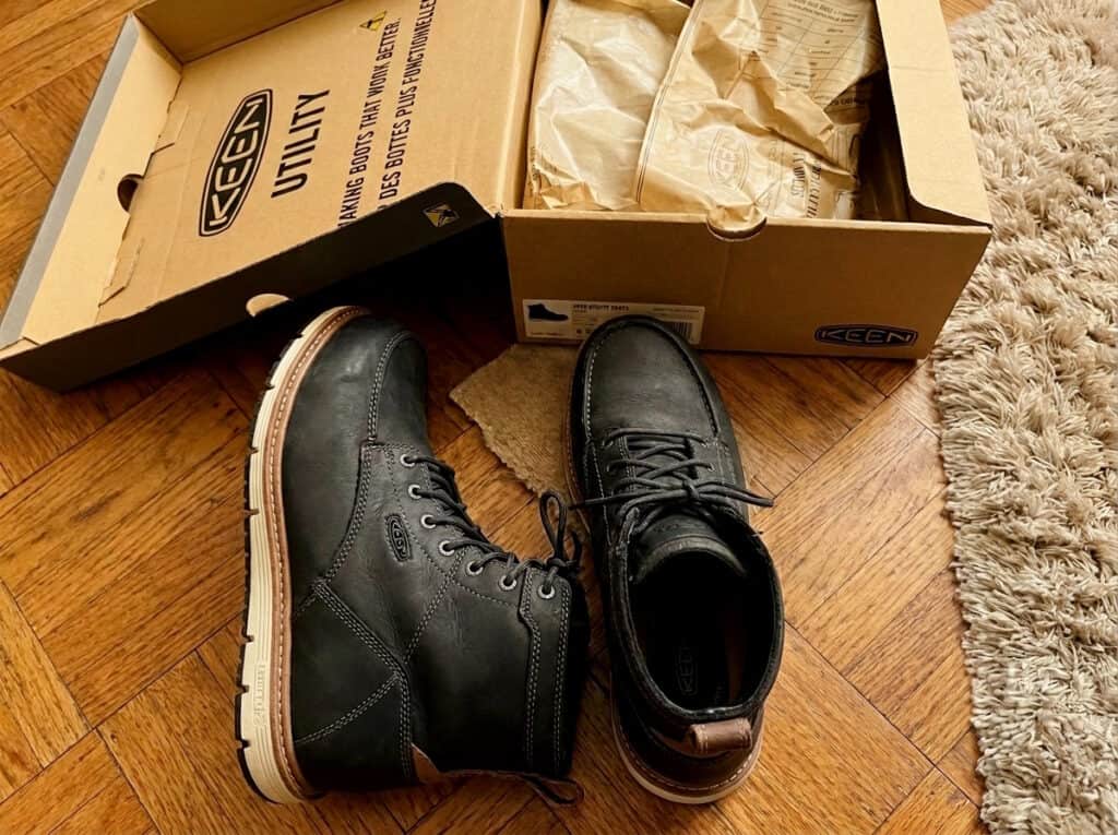 KEEN Utility San Jose 6 inch alloy toe work boots in black with white wedge soles next to the KEEN Utility box