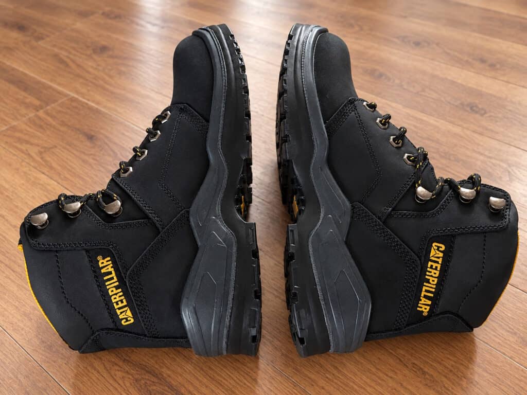 Pair of CAT Striver Steel Toe Work Boots in black with rugged soles, suitable for industrial and construction environments.