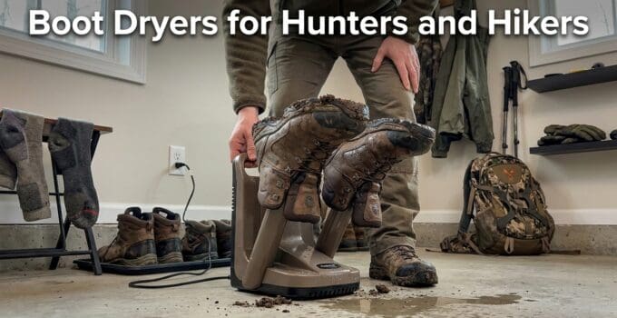 A person using a boot dryer to dry hiking boots in a room with outdoor gear and shoes around.