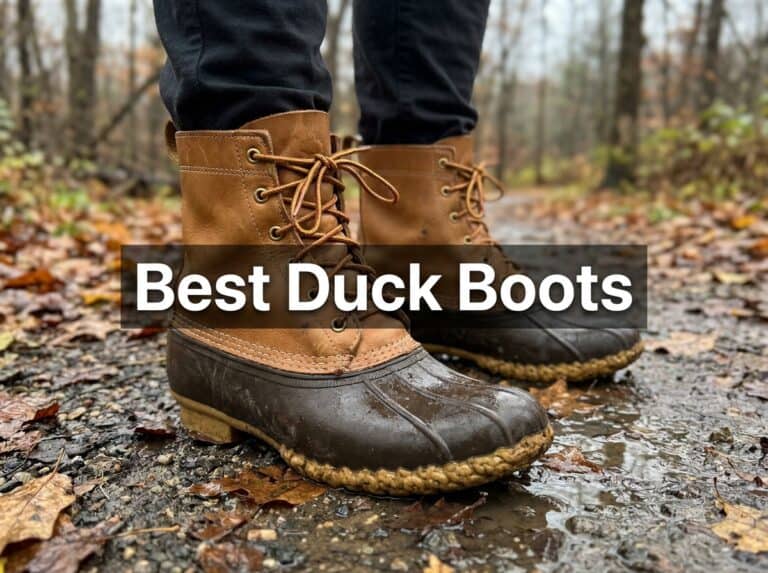 Brown duck boots on a muddy trail with fallen leaves, showing waterproof design and rugged soles for wet conditions.